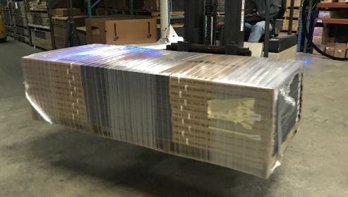 Forklift carrying steel doors wrapped in stretch wrap by TAB Wrapper Tornado