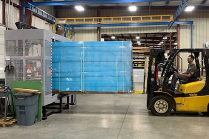 Forklift driver at Penn Sheet Metal, Allentown, PA uses TAB Wrapper Tornado orbital stretch wrapper to wrap pallet load of blue products