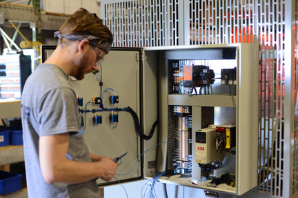 Technician checking electrical panel on TAB Wrapper Tornado orbital wrapper