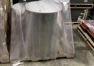 Three round, metal drums stretch wrapped to a pallet using the TAB Wrapper Tornado orbital stretch wrapper